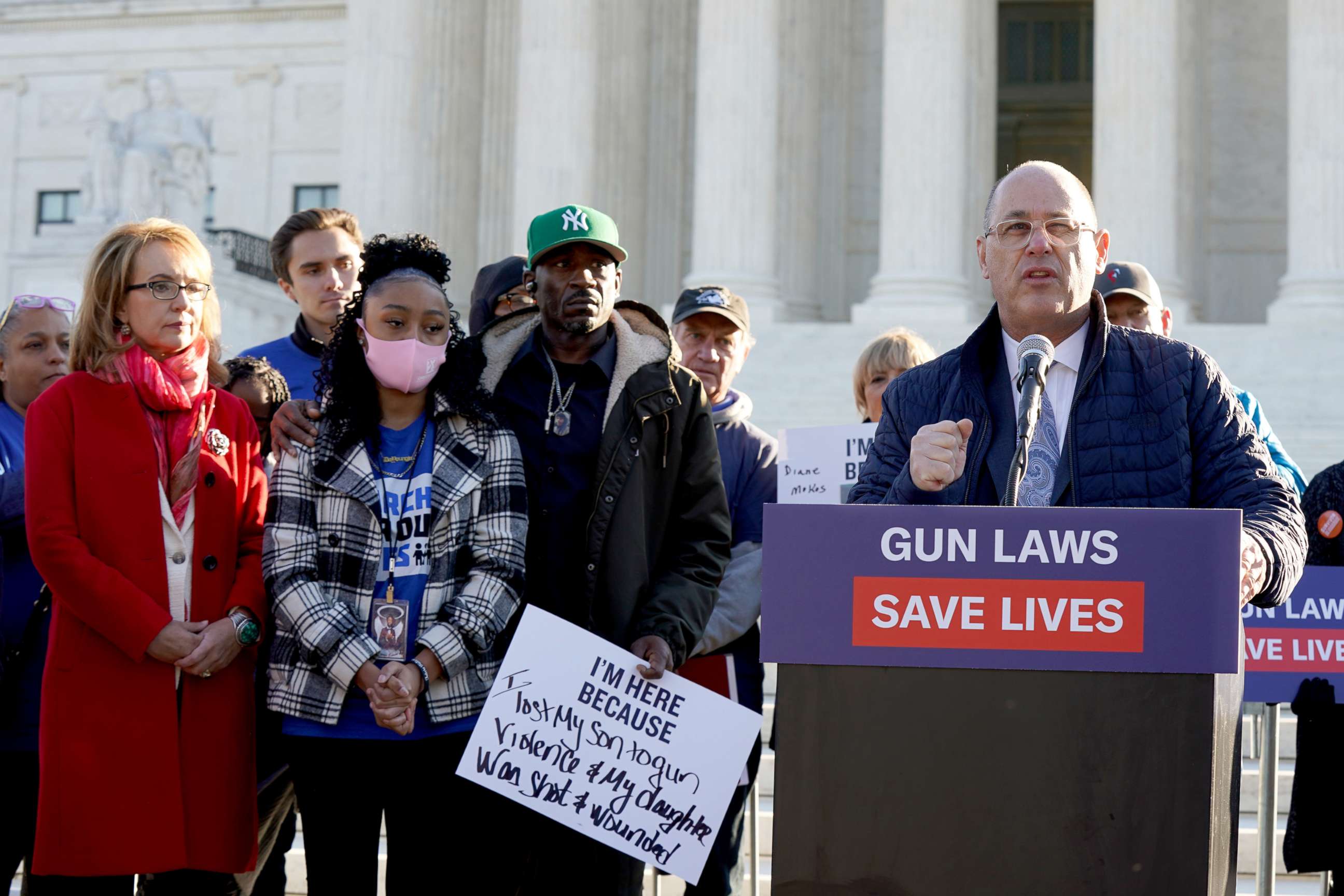 PHOTO: Fred Guttenberg speaks as Gabby Giffords, wearing a red coat, stands with other gun violence survivors gathered in front of the Supreme Court ahead of oral argument in NYSRPA v. Bruen on Nov. 3, 2021 in Washington, D.C.