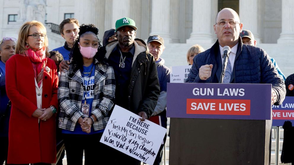 PHOTO: Fred Guttenberg speaks as Gabby Giffords, wearing a red coat, stands with other gun violence survivors gathered in front of the Supreme Court ahead of oral argument in NYSRPA v. Bruen on Nov. 3, 2021 in Washington, D.C.