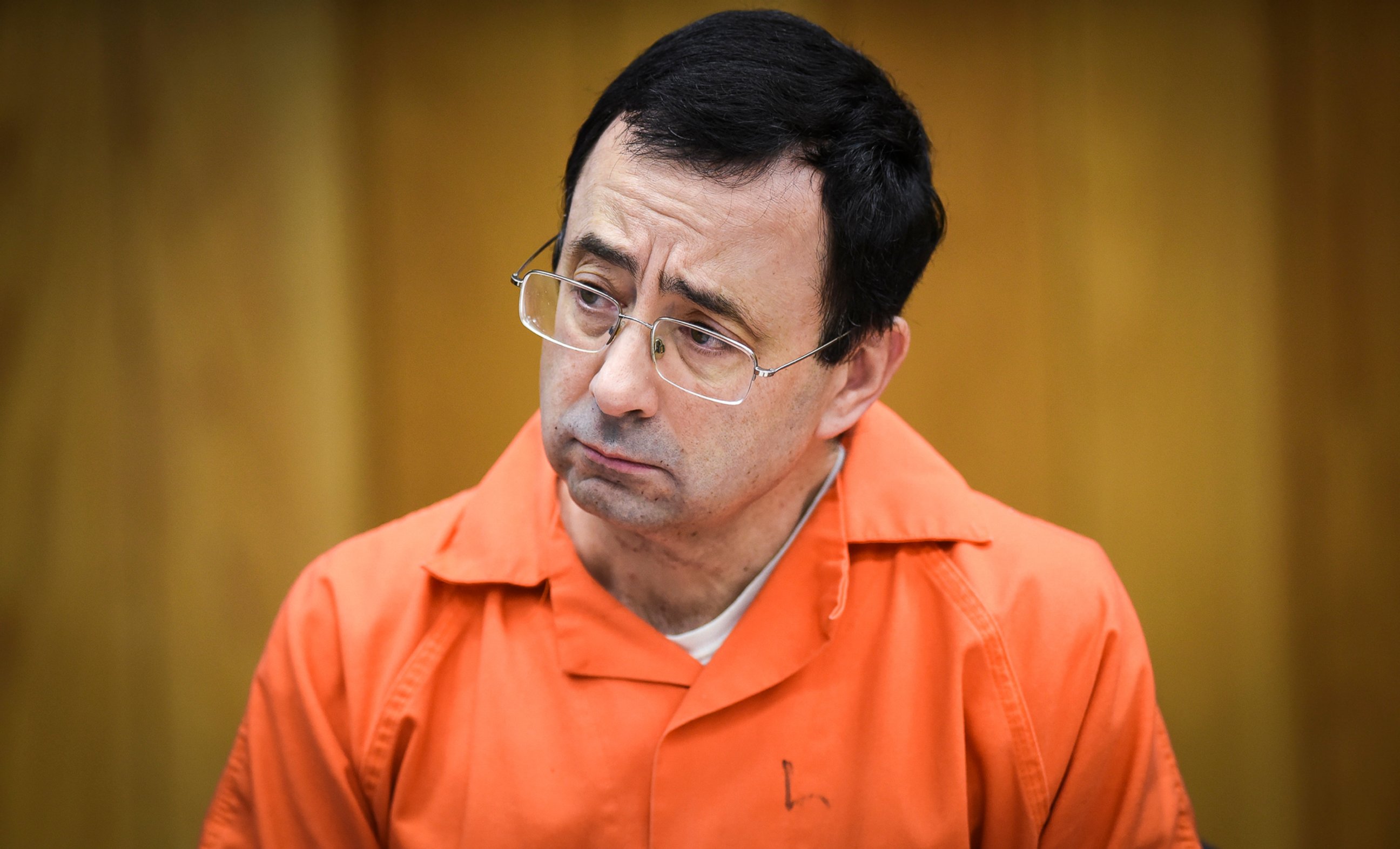 In this Feb. 2, 2018, file photo, Larry Nassar listens as Melissa Alexander Vigogne gives her victim statement in Eaton County Circuit Court in Charlotte, Michigan.