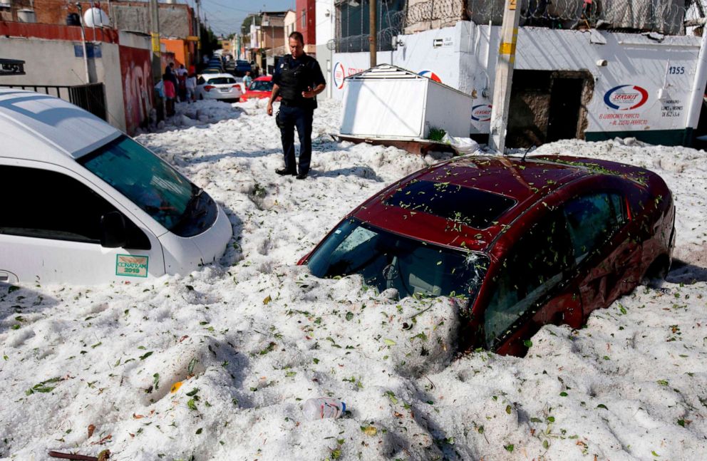 PHOTO: A policeman stands next to vehicles buried by hail in the eastern area of Guadalajara, Jalisco state, Mexico, June 30, 2019.