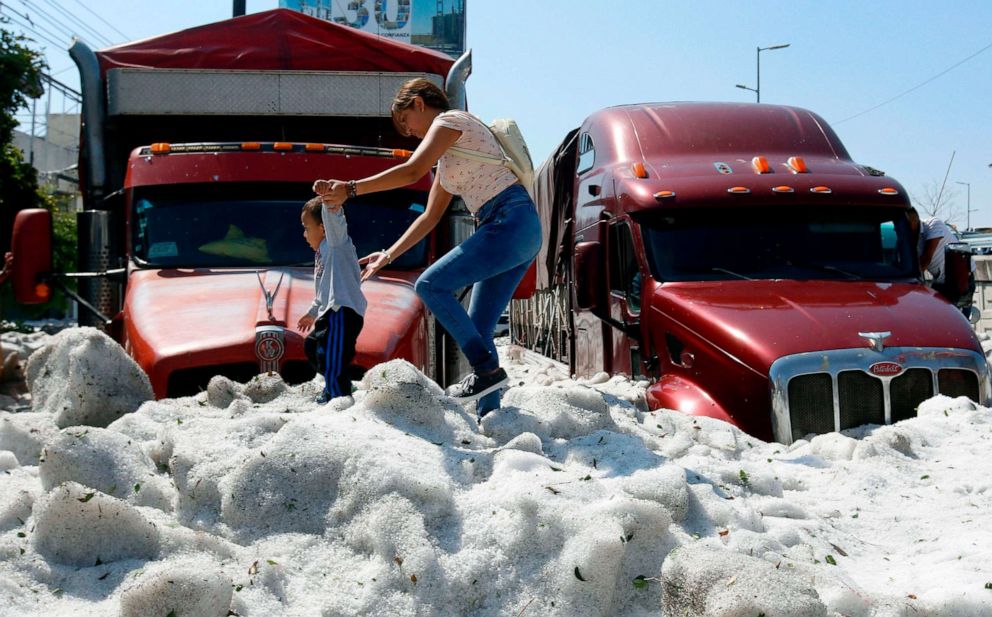 PHOTO: A woman and a child walk over hail in the eastern area of Guadalajara, Jalisco state, Mexico, June 30, 2019.