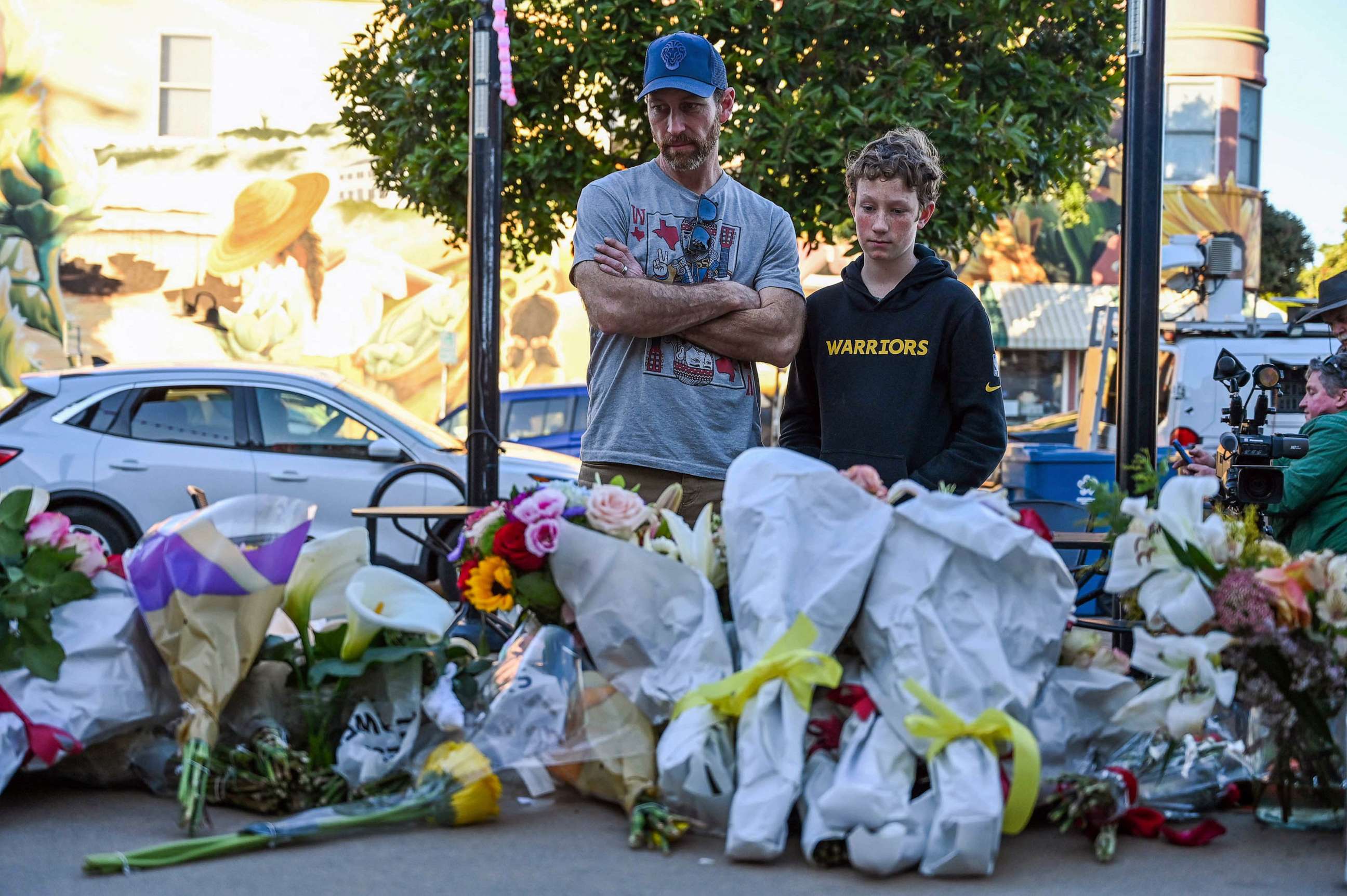 PHOTO: Matt Jones and his son Ryder Jones pay their respects at a makeshift memorial for those killed during a shooting in Half Moon Bay, Calif., Jan. 25, 2023.