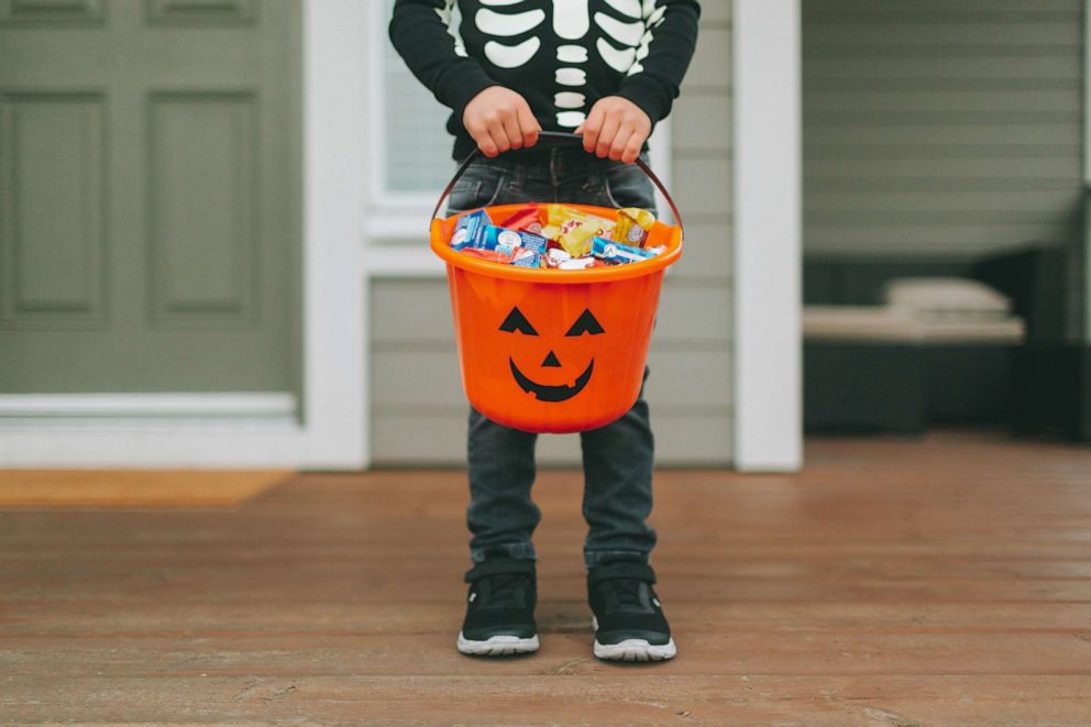 PHOTO: Trick or treater with bucket of candy.