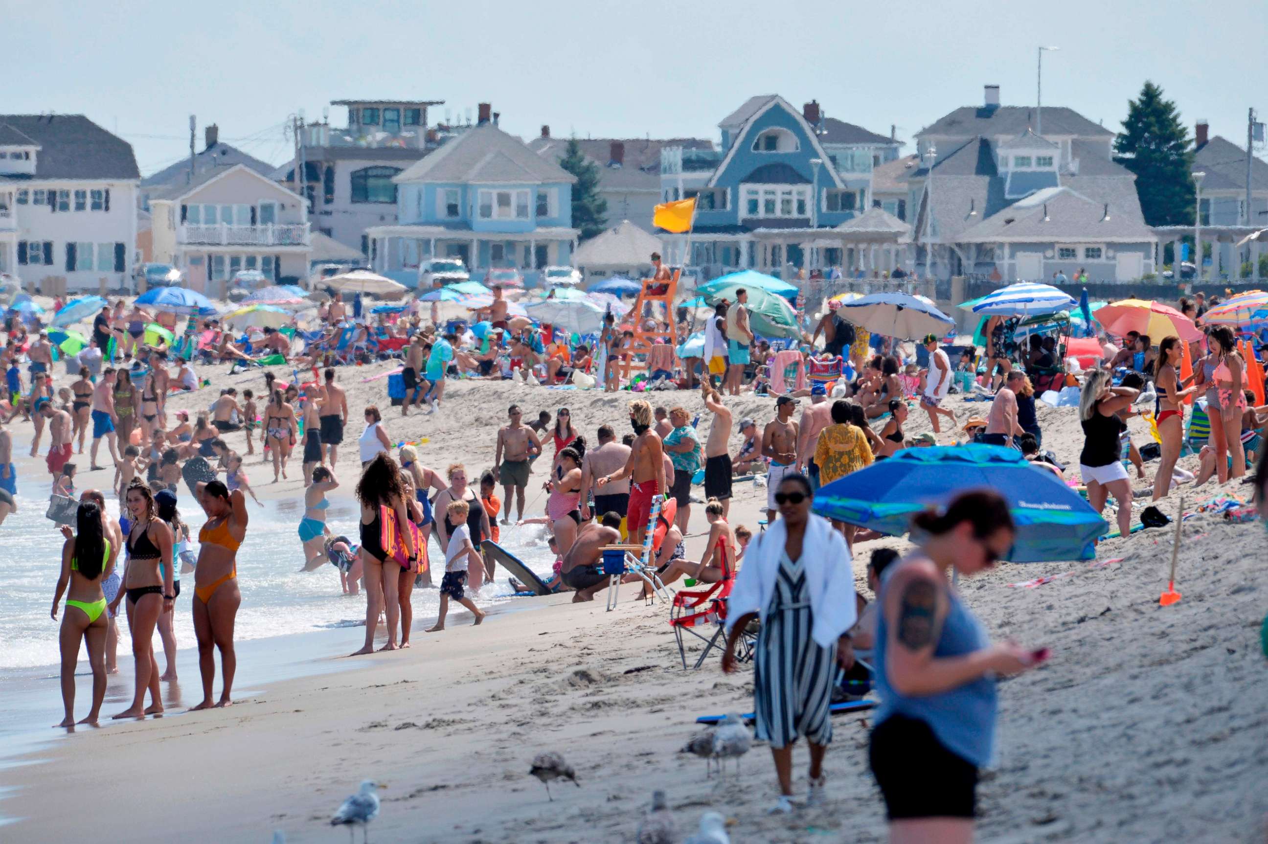 PHOTO: People walk on the shore at Hampton Beach in Hampton, New Hampshire, on Aug. 5, 2020, as COVID-19 cases in New England are on the rise.