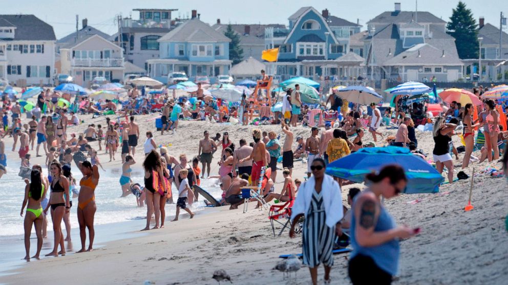 PHOTO: People walk on the shore at Hampton Beach in Hampton, New Hampshire, on Aug. 5, 2020, as COVID-19 cases in New England are on the rise.