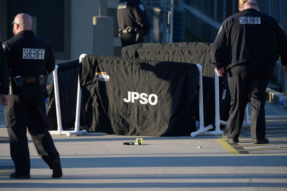PHOTO: A gun is seen next to the curtains in front of a dead body at the scene of a multiple fatality shooting at the Jefferson Gun Outlet in Metairie, La., Feb. 20, 2021.