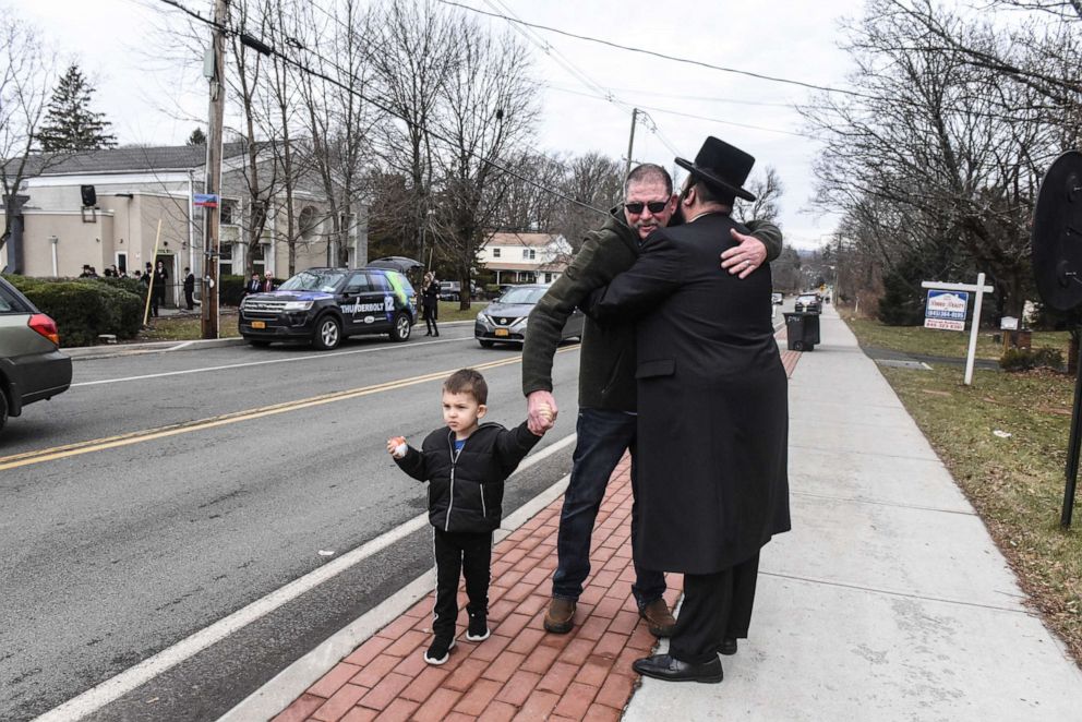 PHOTO: A member of Rabbi Chaim Rottenberg's community, right, hugs a well wisher in front of the rabbi's house on Dec. 29, 2019, in Monsey, N.Y.