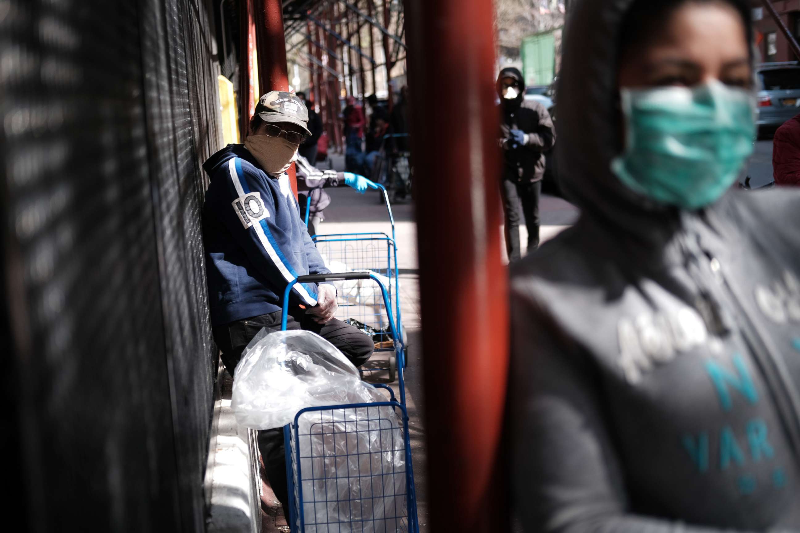 PHOTO: People wait at a food distribution site that has seen a surge in demand due to the coronavirus outbreak, April 7, 2020 in the Harlem neighborhood of the Bronx, in New York City.