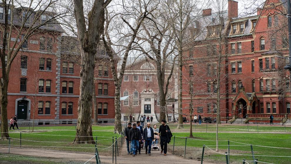 PHOTO: People walk through Harvard Yard on the Harvard University campus in Cambridge, Massachussetts, April 15, 2025.