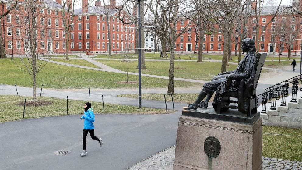 PHOTO: A runner crosses Harvard Yard on March 23, 2020, in Cambridge, Mass. Students were required to be out of their dorms no later than March 15 and finish the rest of the semester online due to the ongoing COVID-19 pandemic..