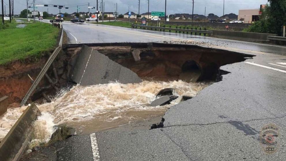 PHOTO: Water rushes from a large sinkhole on Highway FM 762 in Rosenberg, Texas, near Houston, Aug. 27, 2017. Police say the sinkhole has opened on the Texas highway as Tropical Storm Harvey dumps more rain on the region.