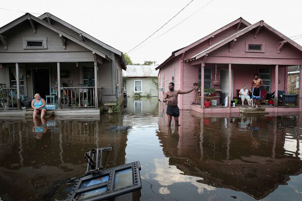 PHOTO: Residents hang out in front of their homes which are surrounded by floodwater after torrential rains pounded Southeast Texas following Hurricane and Tropical Storm Harvey causing widespread flooding on September 2, 2017, in Orange, Texas.
