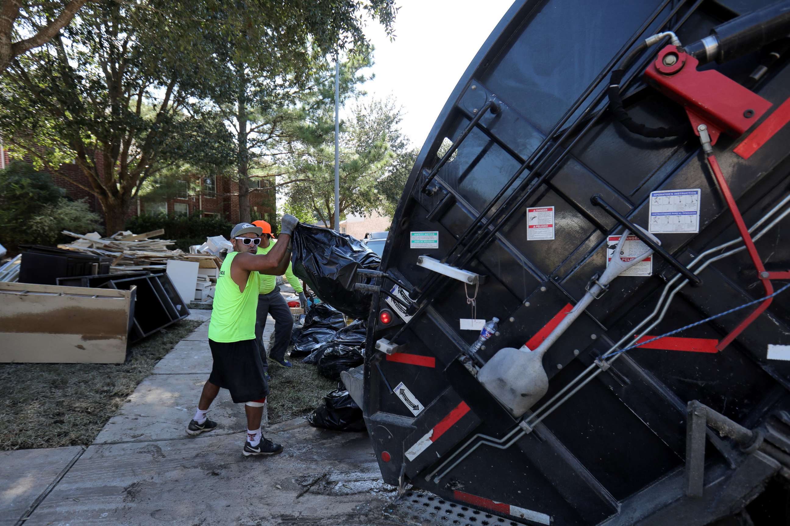 PHOTO: A garbage truck helps residents remove bags of flood-damaged items that line the streets of numerous neighborhoods in the aftermath of tropical storm Harvey on the west side of Houston, Texas, U.S., Sept. 7, 2017.