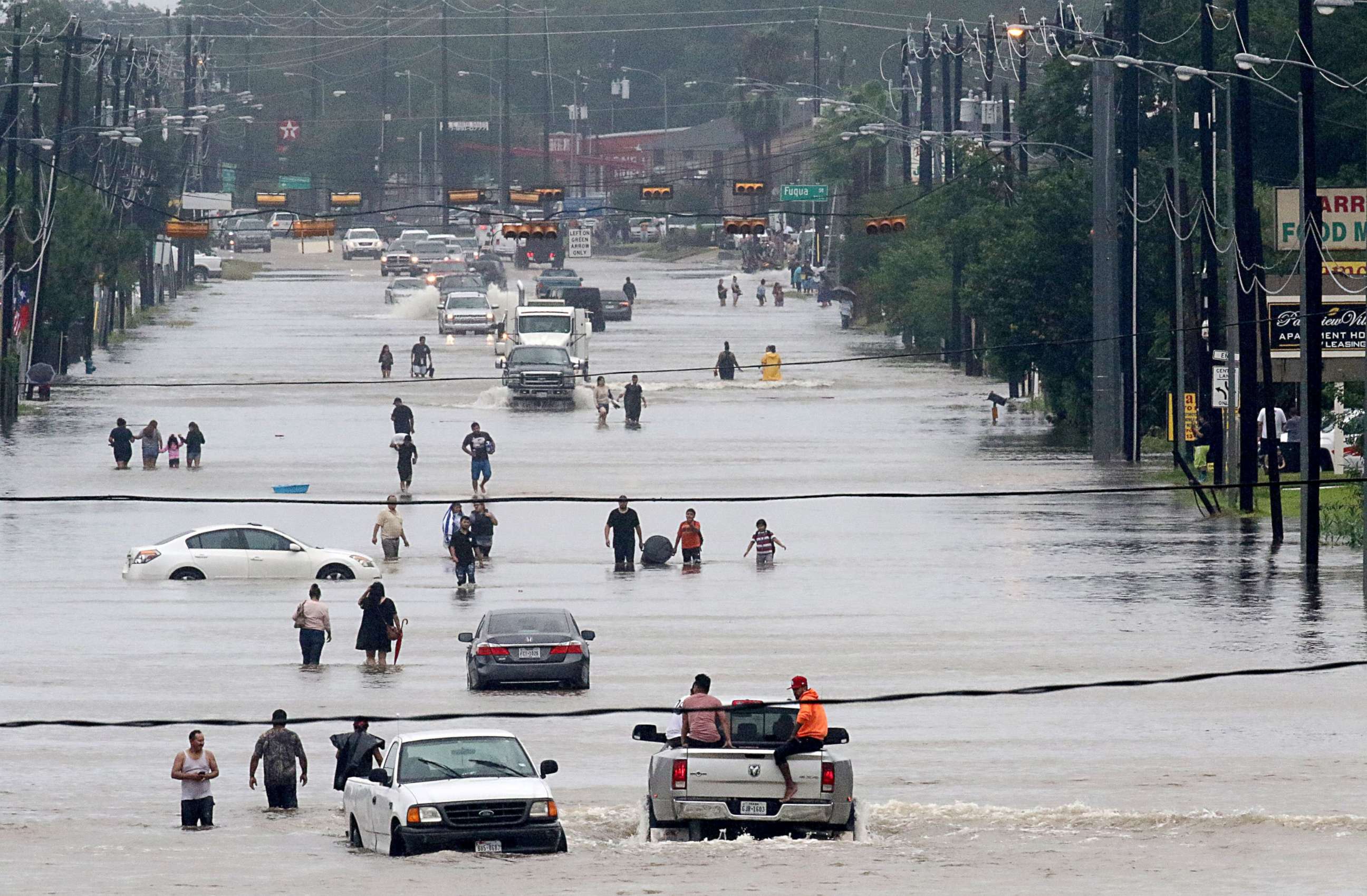 PHOTO: People walk through the flooded waters of Telephone Rd. in Houston, Aug. 27, 2017, as the city battles with tropical storm Harvey and resulting floods. 