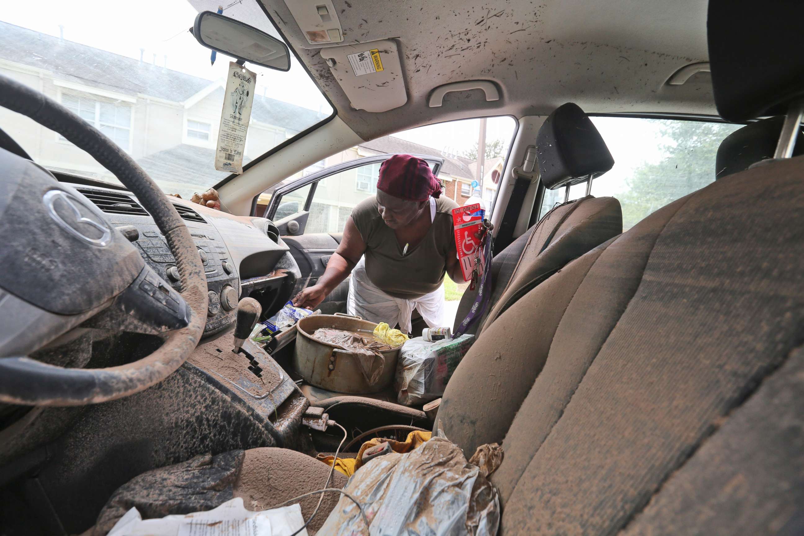 PHOTO: Gillis Leho looks for documents in her car that was covered by floodwaters after Tropical Storm Harvey in Houston, Texas, Aug. 30, 2017.