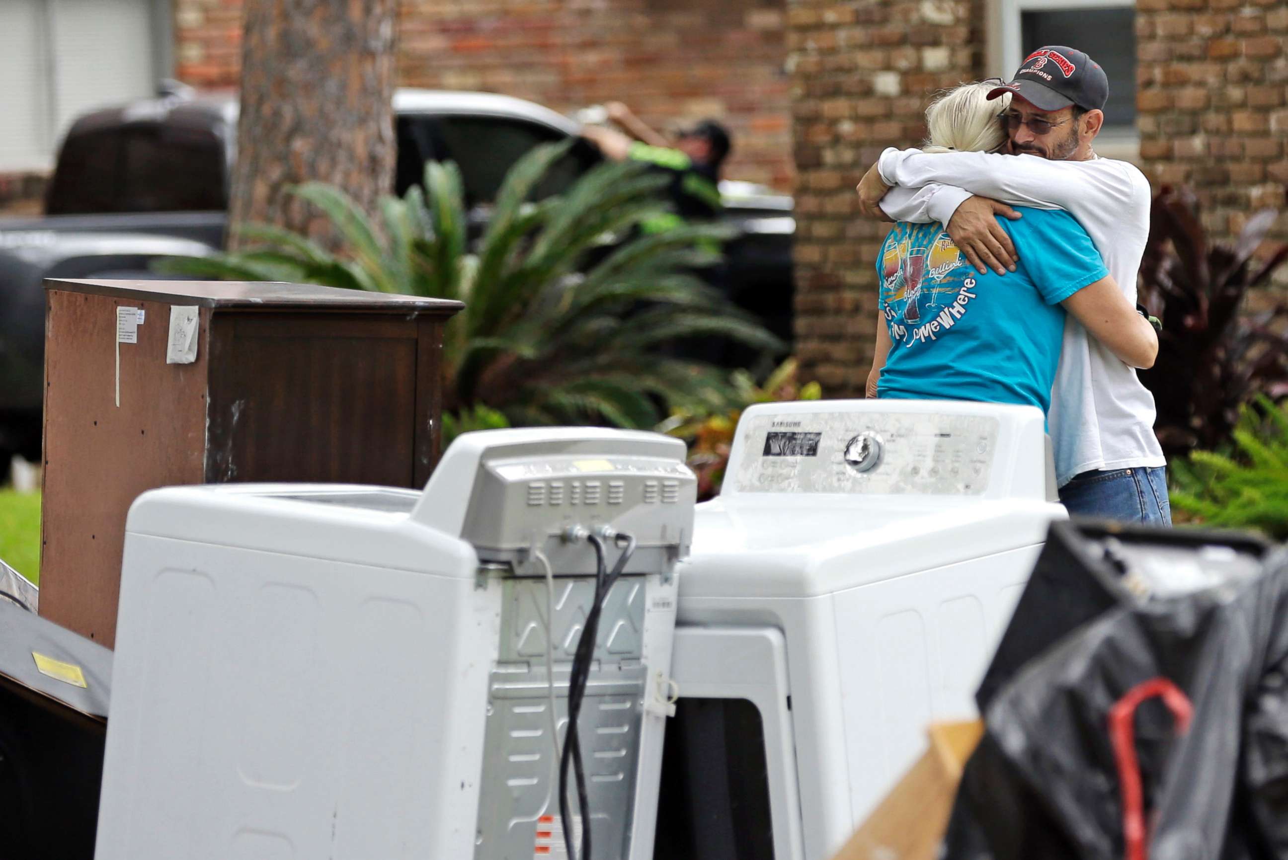 PHOTO: Barry Horvitz hugs his wife Kim while standing outside their home after removing items damaged by floodwaters from Tropical Storm Harvey on Aug. 30, 2017, in Houston, Texas.
