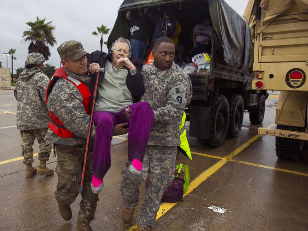 PHOTO: Texas Army National Guard members Sergio Esquivel, left, and Ernest Barmore carry 81-year-old Ramona Bennett after she was rescued, Aug. 29, 2017 in Houston, Texas.