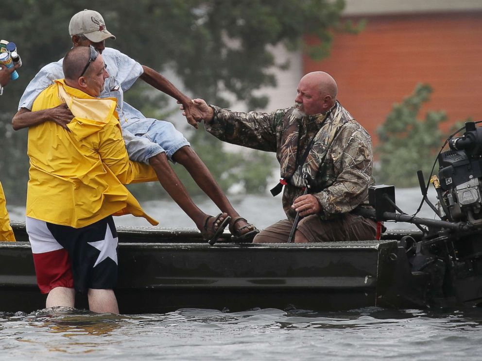 PHOTO: Rescuers help a man leave the flooded area in Port Arthur, Texas following torrential rains from Hurricane Harvey, Aug. 30, 2017. 