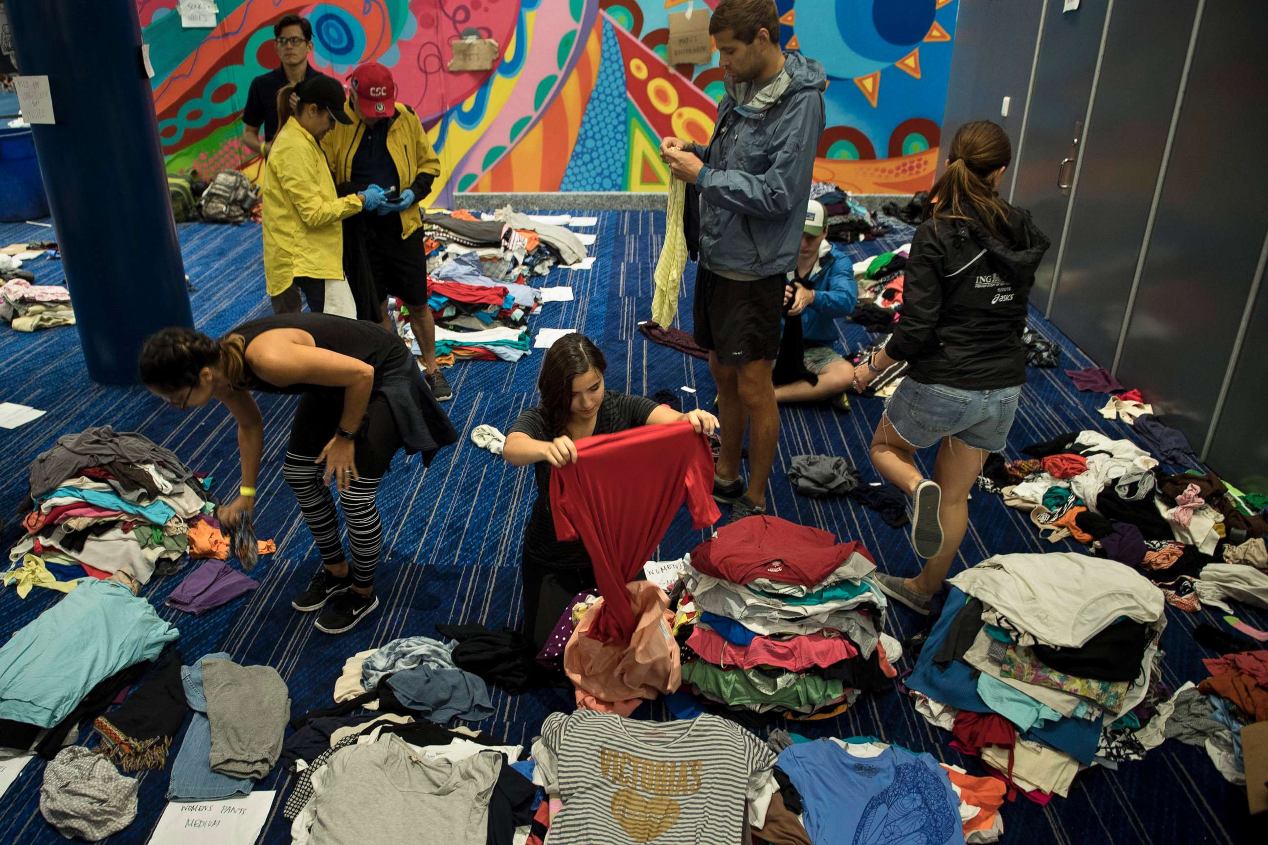 PHOTO: Volunteers sort through donated clothing at a shelter in the George R. Brown Convention Center during the aftermath of Hurricane Harvey, Aug. 28, 2017, in Houston.