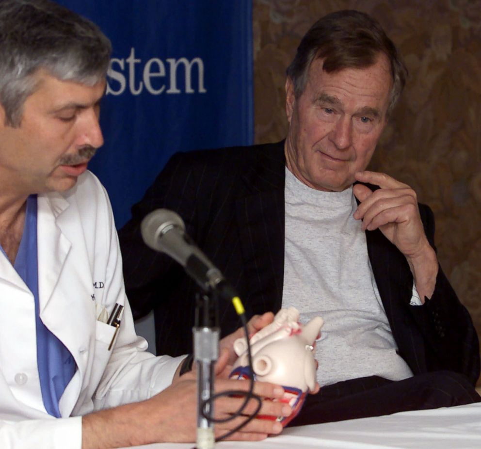 PHOTO: Former President George HW Bush, right, listens to cardiologist Mark Hausknecht talk about Bush's heart condition, during a news conference at Methodist Hospital, Feb. 25, 2000, in Houston.