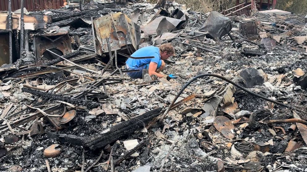 PHOTO: Andres Fehlman looks for his and his wife’s wedding rings amid the rubble of their home.