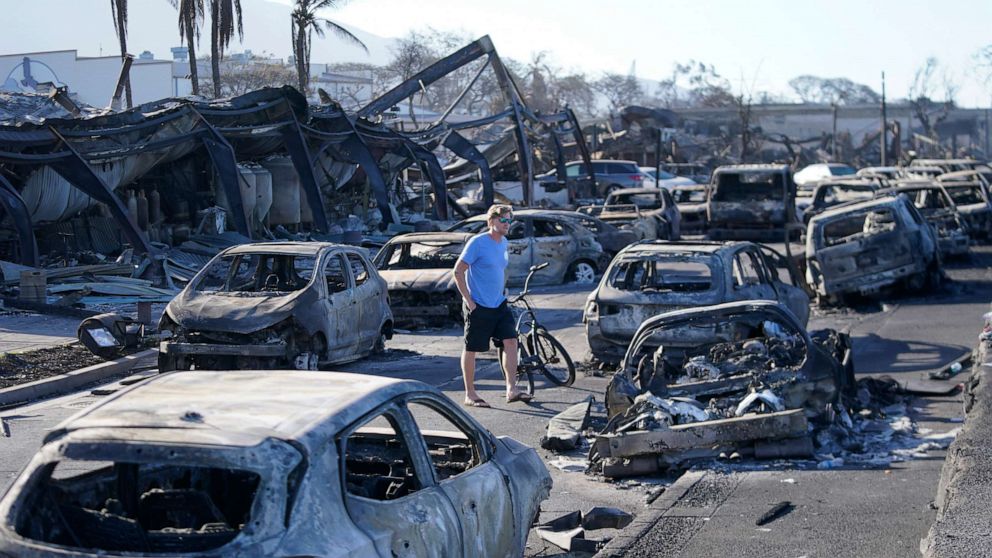 PHOTO: A man walks through wildfire destruction, Aug. 11, 2023, in Lahaina, Hawaii.