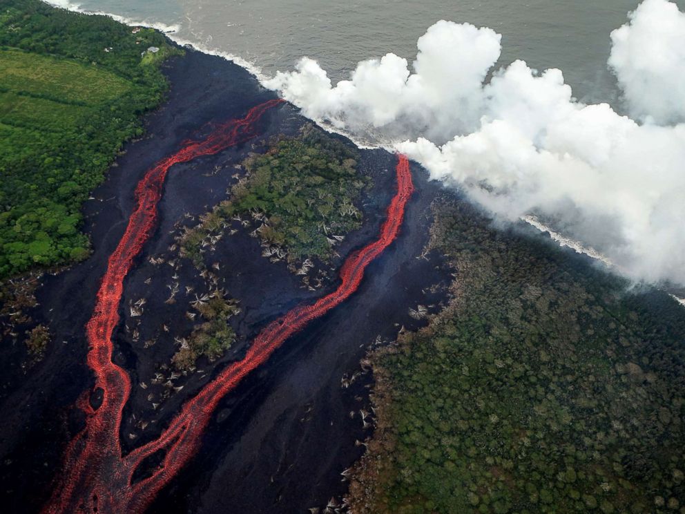 PHOTO: Steam plumes rise as lava enters the Pacific Ocean, after flowing to the water from a Kilauea volcano fissure, on Hawaiis Big Island, May 21, 2018, near Pahoa, Hawaii.
