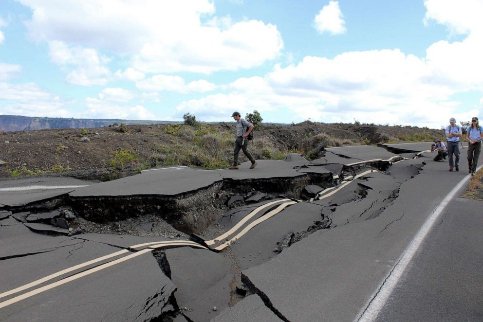 PHOTO: Tourists walk around a road damaged by earthquakes in Hawaii's Volcanoes National Park.