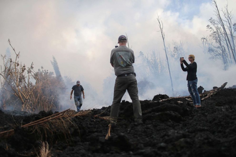 PHOTO: Neighbors survey lava damage in the Leilani Estates neighborhood in the aftermath of eruptions from the Kilauea volcano on Hawaii's Big Island on May 9, 2018 in Pahoa, Hawaii.