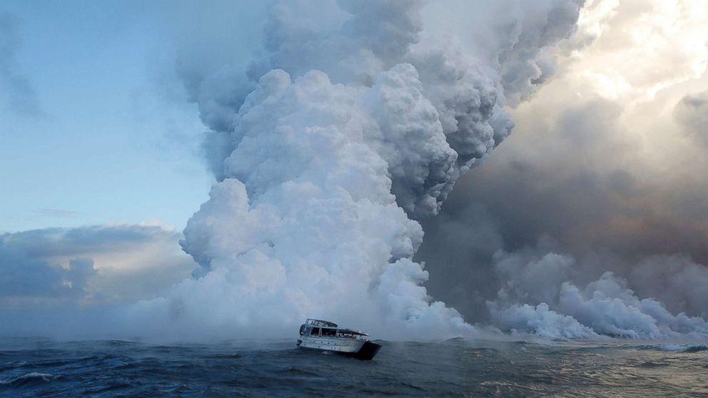 PHOTO: People watch from a tour boat as lava flows into the Pacific Ocean in the Kapoho area, east of Pahoa, during ongoing eruptions of the Kilauea Volcano in Hawaii, June 4, 2018.