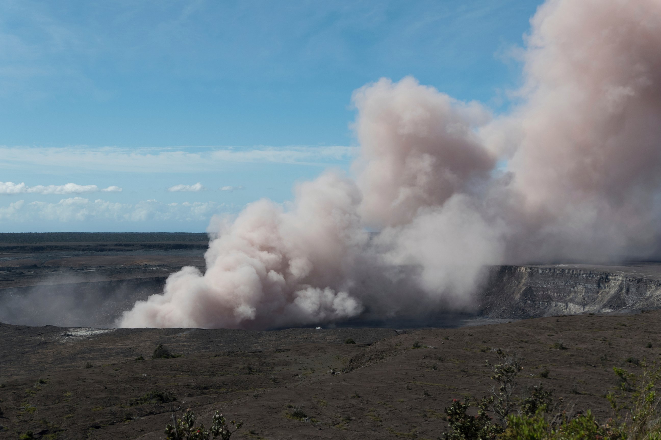 In this Friday, May 11, 2018 photo released by the U.S. Geological Survey, an ash plume rises from the Overlook Vent in Halema'uma'u crater of the Kilauea volcano on the Big Island of Hawaii.