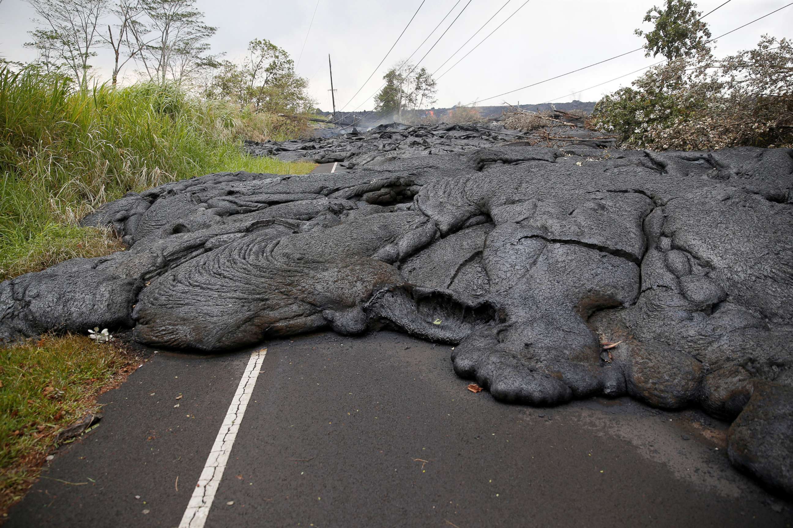 PHOTO: Lava covers Pohoiki Road near Pahoa, Hawaii, May 29, 2018.