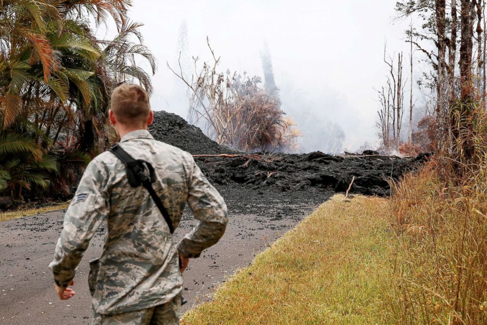 PHOTO: Senior Airman John Linzmeier, of the Hawaii National Guard, observes a lava flow in the Leilani Estates subdivision during ongoing eruptions of the Kilauea Volcano in Hawaii, May 13, 2018.