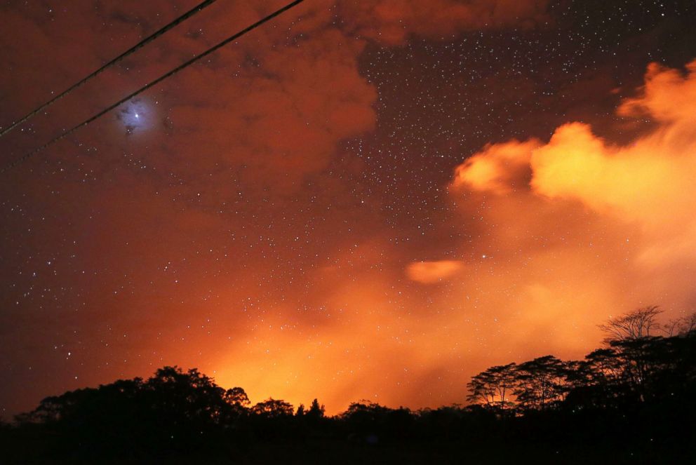 PHOTO: Lava from active fissures illuminates volcanic gases from the Kilauea volcano as stars shine on Hawaii's Big Island, May 15, 2018, in Hawaii Volcanoes National Park, Hawaii.