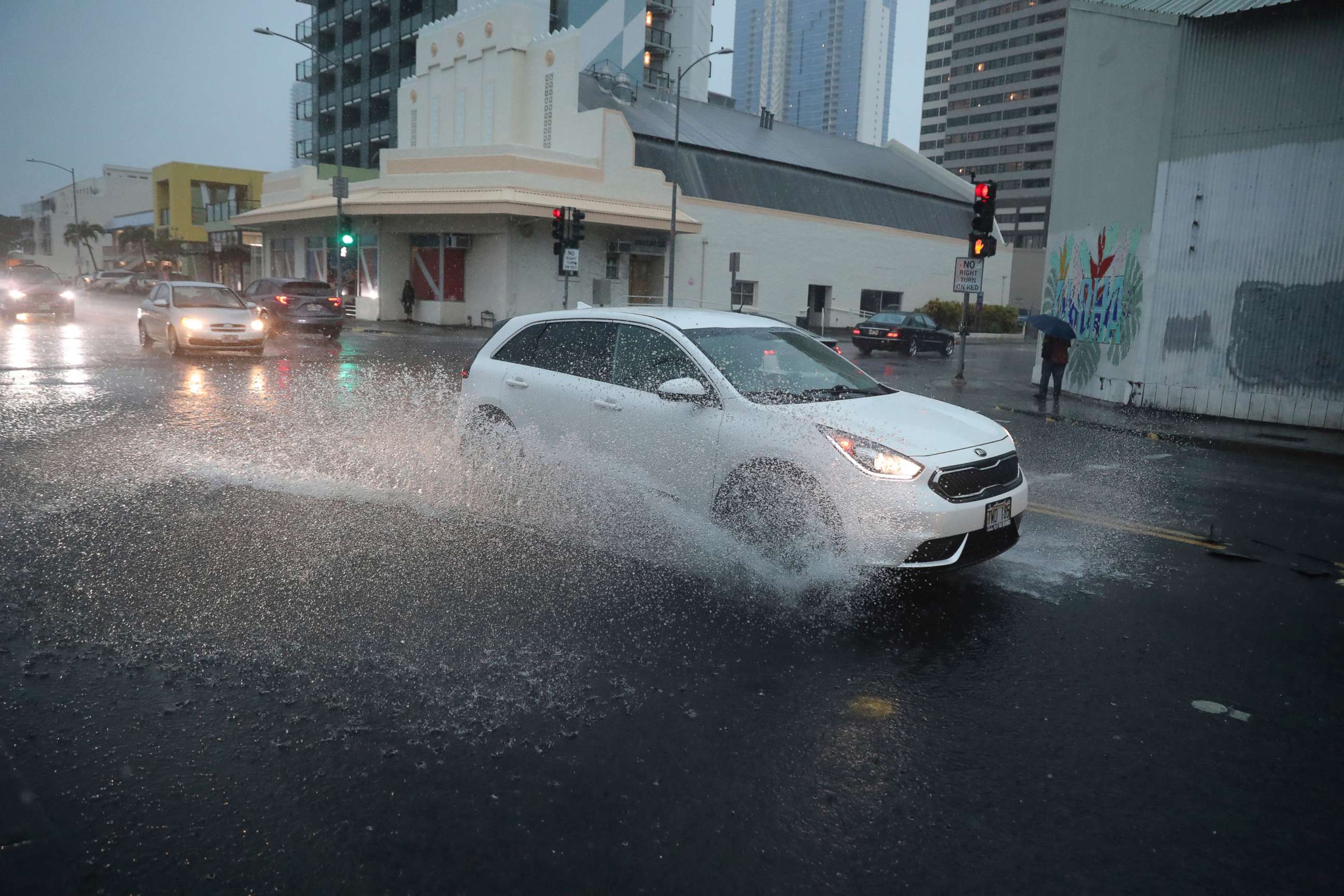 PHOTO: A car turns onto a flooded Cooke Street, Dec. 6, 2021, in Honolulu.