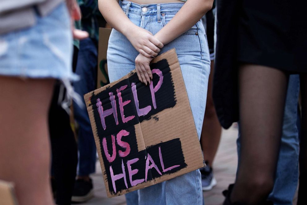 PHOTO: A university student holds a sign during a rally demanding better counseling and mental health services for all students on Dec. 2, 2021, in Santa Clara, Calif.