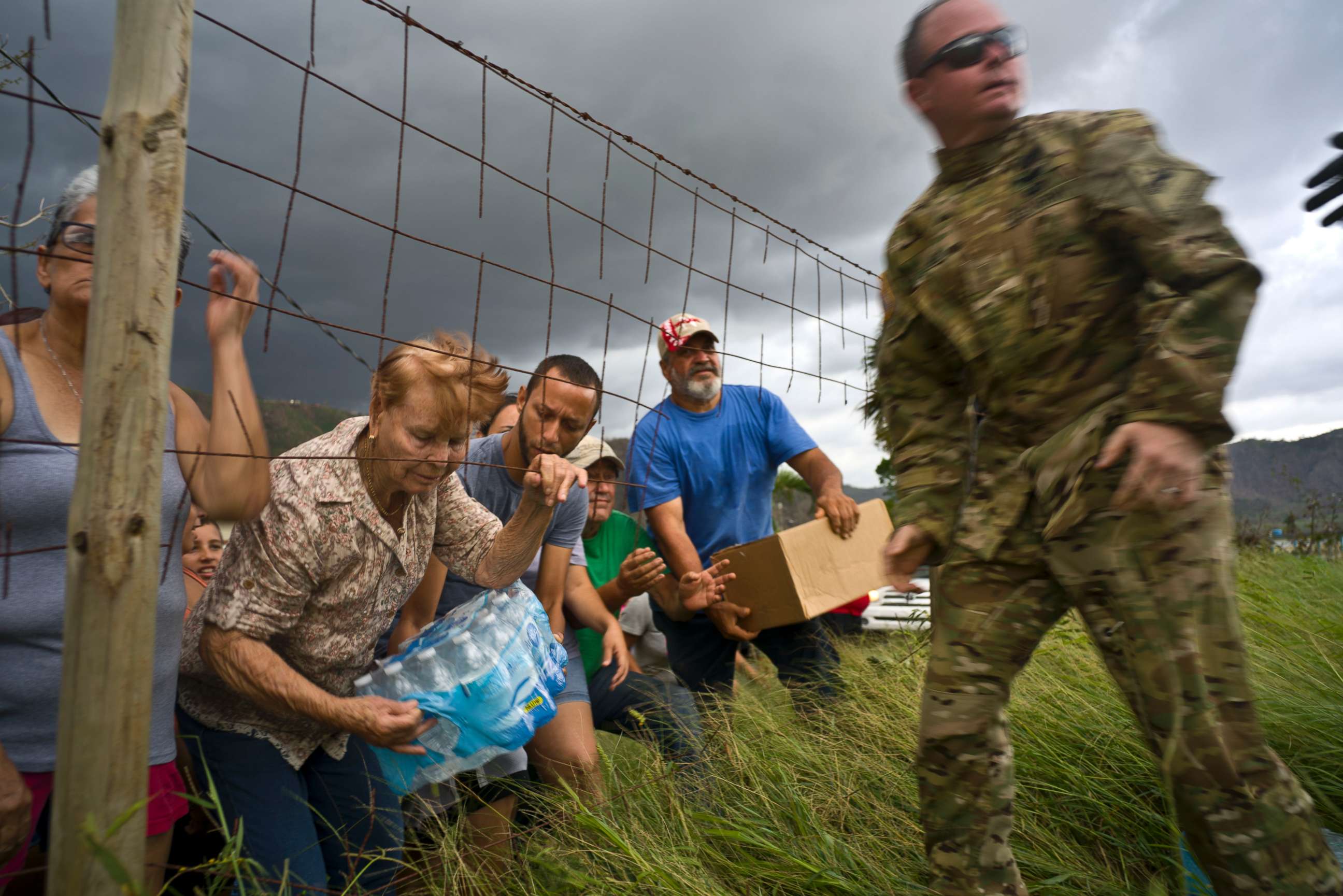 PHOTO: A member of the Puerto Rican National Guard delivers food and water brought via helicopter to victims of Hurricane Maria, in the San Lorenzo neighborhood of Morovis, Puerto Rico, Oct. 7, 2017.