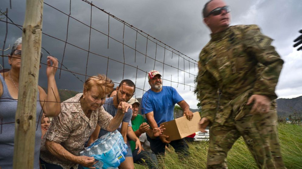 PHOTO: A member of the Puerto Rican National Guard delivers food and water brought via helicopter to victims of Hurricane Maria, in the San Lorenzo neighborhood of Morovis, Puerto Rico, Oct. 7, 2017.