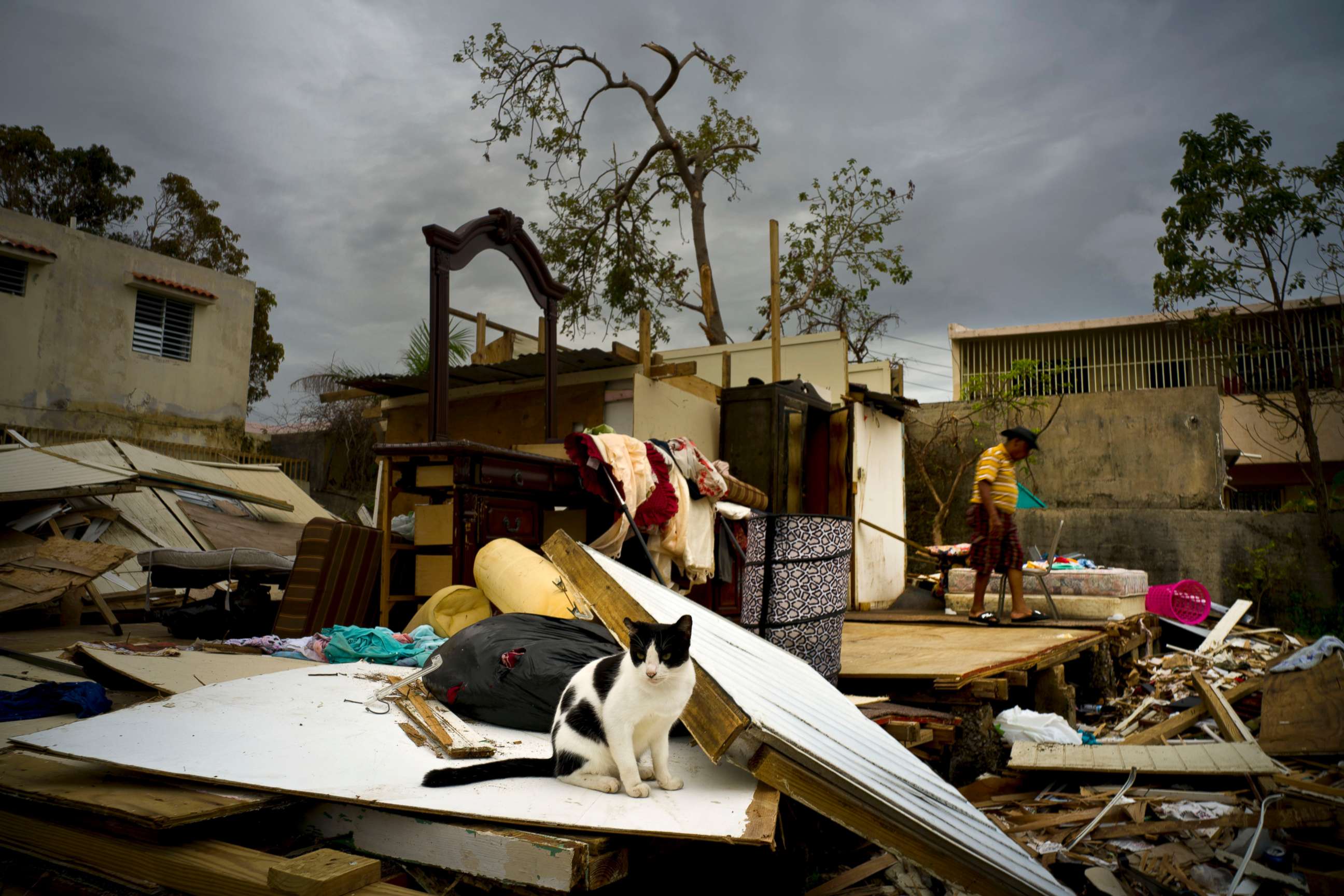 PHOTO: Efrain Diaz Figueroa, right, walks by his sister's home destroyed in the passing of Hurricane Maria, in San Juan, Puerto Rico, Oct. 9, 2017. 