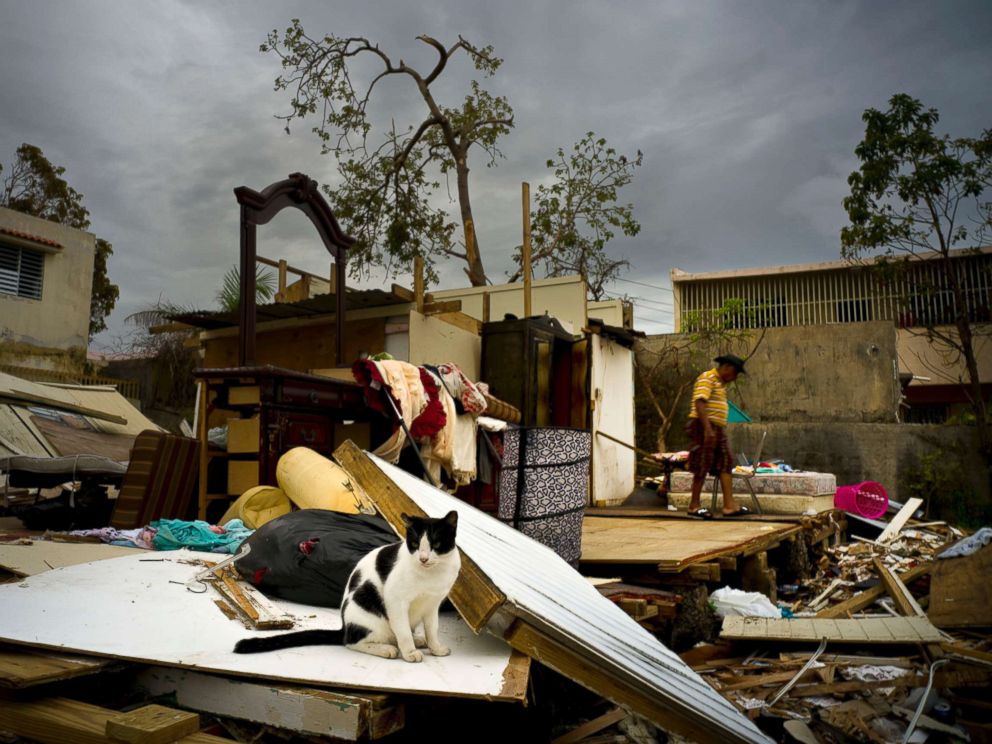 PHOTO: Efrain Diaz Figueroa, right, walks by his sisters home destroyed in the passing of Hurricane Maria, in San Juan, Puerto Rico, Oct. 9, 2017.