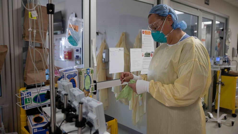 PHOTO: A health care professional suits up with personal protective equipment (PPE) before entering a COVID-19 patient's room in the intensive care unit (ICU) at Van Wert County Hospital in Van Wert, Ohio, on Nov. 20, 2020.
