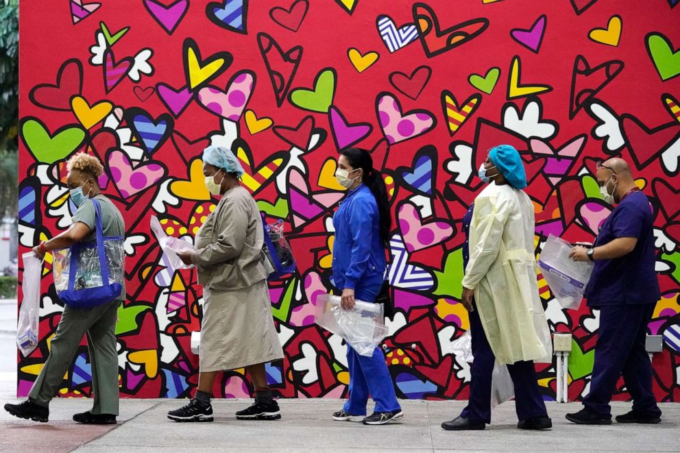 PHOTO: Health care workers line up for free personal protective equipment (PPE) in front of a mural by artist Romero Britto at the Jackson Memorial Hospital in Miami, Florida, on Sept. 22, 2020.