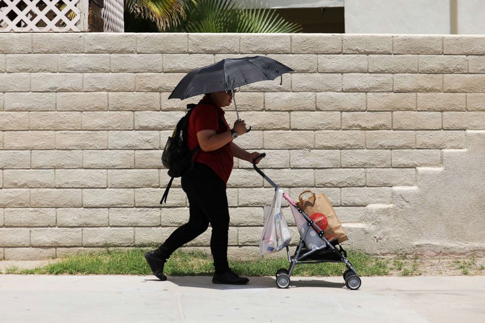 PHOTO: A woman pushes groceries in temperatures which have reached well above triple digits in Palm Springs, Calif., July 20, 2022.