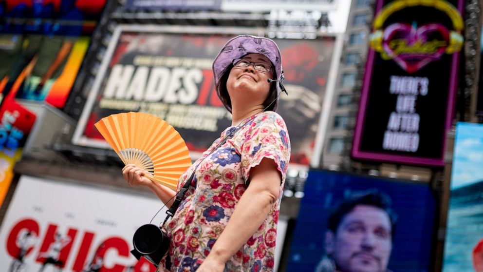 PHOTO: A tour guide fans herself while working in Times Square as temperatures rise, July 27, 2023, in New York City.