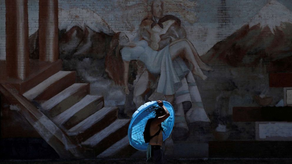 PHOTO: Daniel Bosquez carries a plastic pool to his friend's apartment during an excessive heat warning in San Antonio, Texas, July 11, 2022.