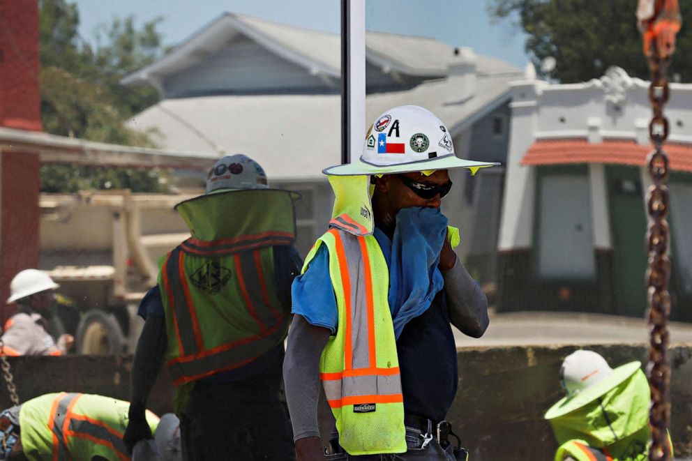 PHOTO: Anthony Harris wipes sweat as he works with E-Z Bel Construction on pipes along Fredericksburg Road during an excessive heat warning in San Antonio, Texas, July 19, 2022.