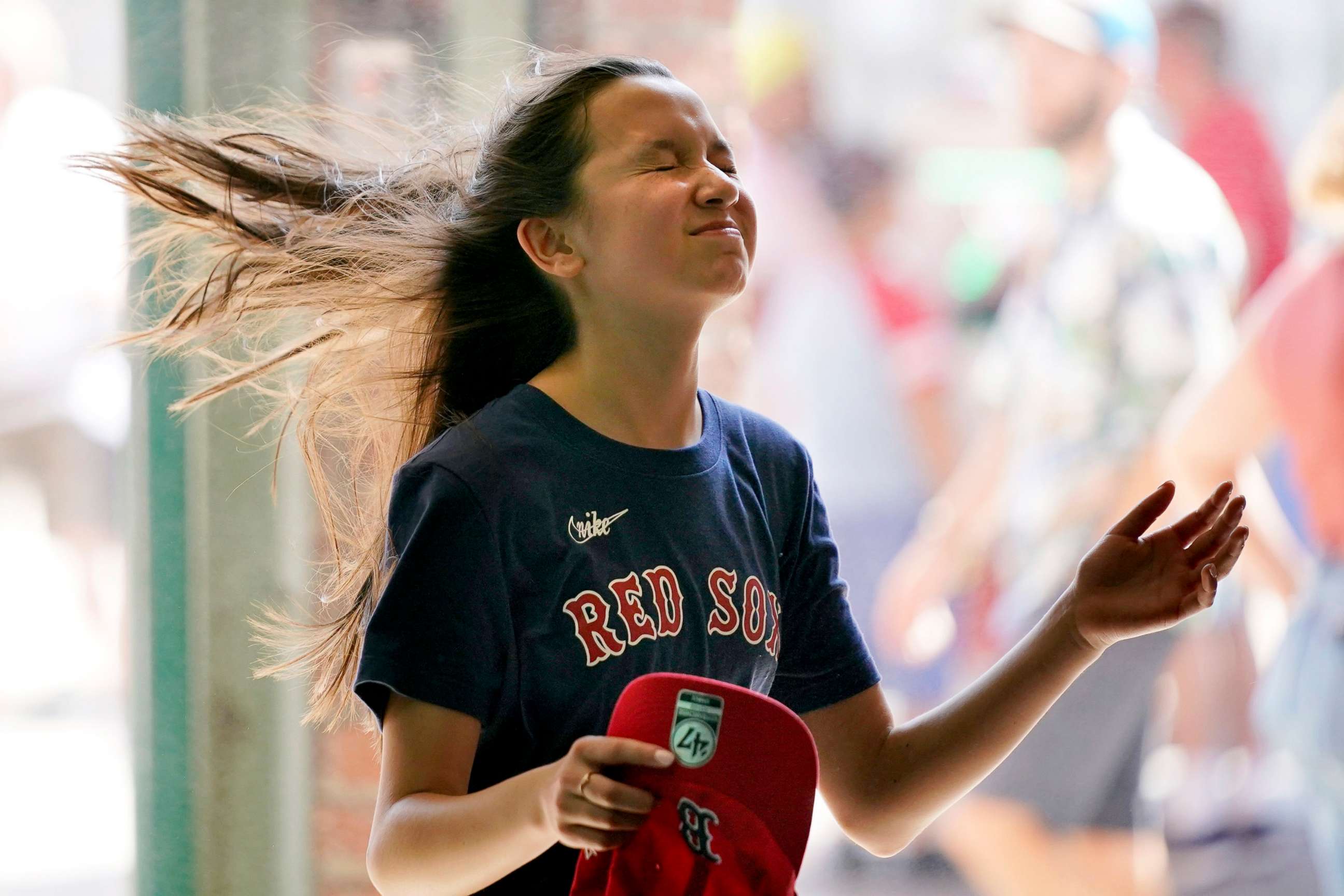 PHOTO: A Boston Red Sox's fan cools off in front of a misting fan at Fenway Park where a heat advisory was in effect before a baseball game against the Seattle Mariners, May 21, 2022, in Boston.