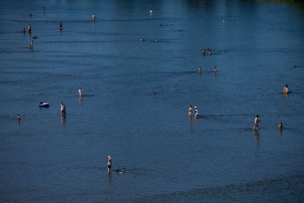 PHOTO: Local residents refresh themselves at the Feather River as the temperature rises over 100 degrees Fahrenheit (38 Celsius) in Yuba City, Calif., June 30, 2023.