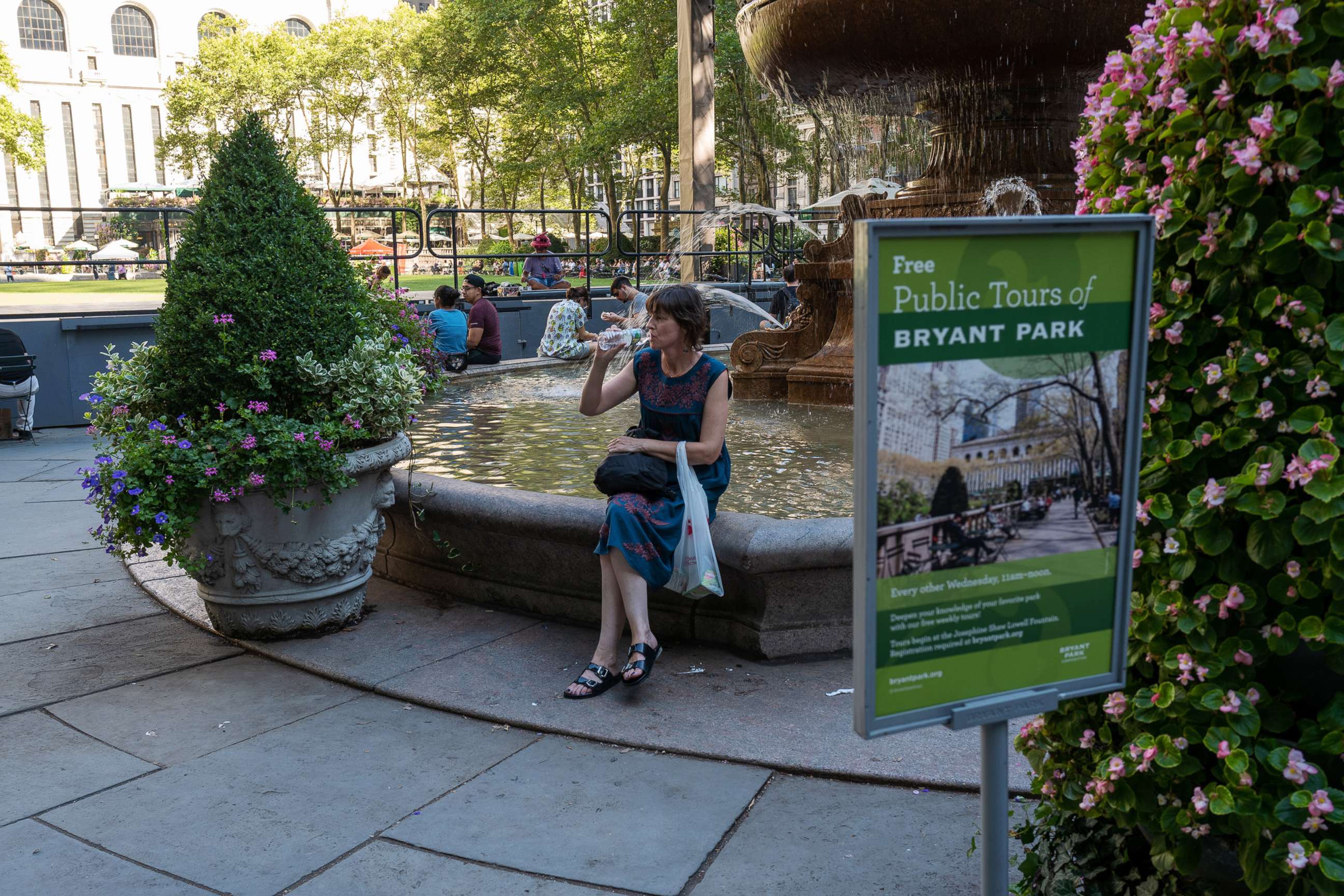 PHOTO: A woman drinks water while sitting in the shade in Bryant Park in midtown Manhattan, Aug. 3, 2022 in New York City.