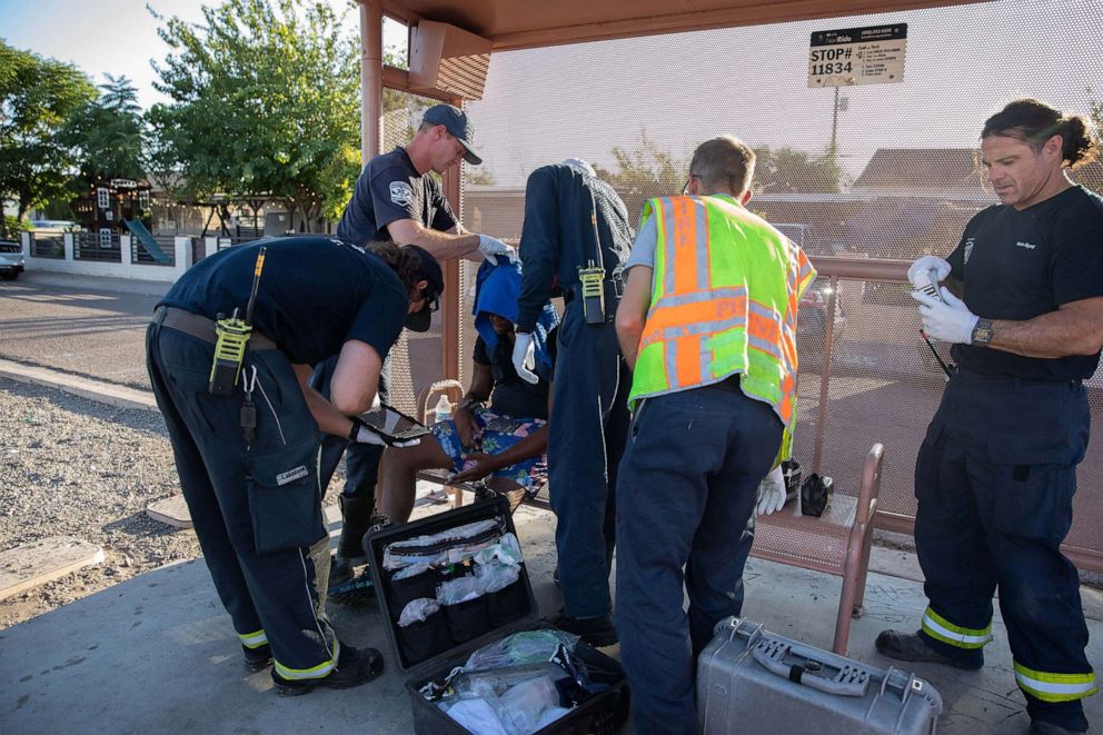 PHOTO: Firefighters from Fire Engine 18 assist a resident having trouble breathing during a heat wave in Phoenix, Arizona, on July 20, 2023. Phoenix extended its record streak of days above 110F to 20 on Wednesday with a high of 119F.